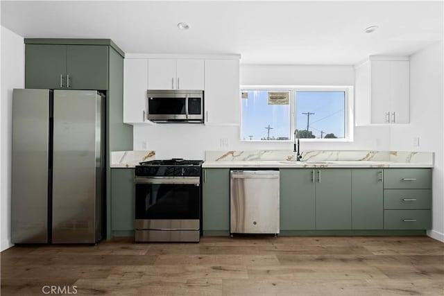 kitchen featuring white cabinets, appliances with stainless steel finishes, light wood-type flooring, and green cabinets