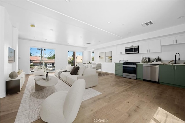 living room featuring sink and light hardwood / wood-style floors