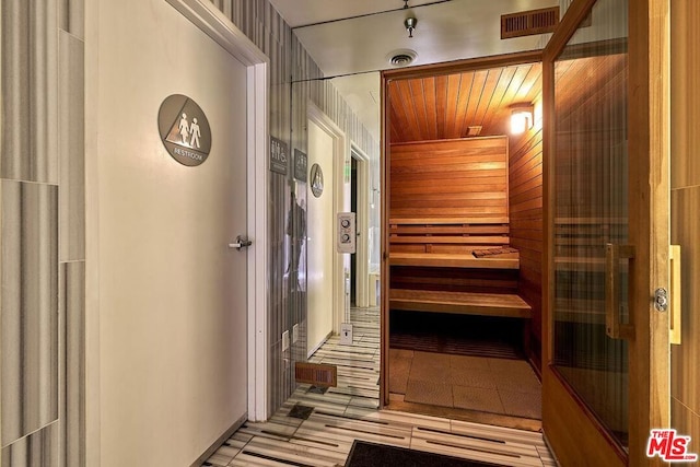 view of sauna featuring wooden walls and hardwood / wood-style flooring