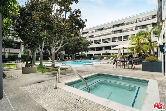 view of swimming pool featuring a patio area and a hot tub