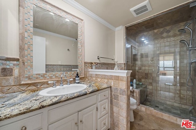 bathroom with vanity, tile walls, crown molding, toilet, and a shower with door