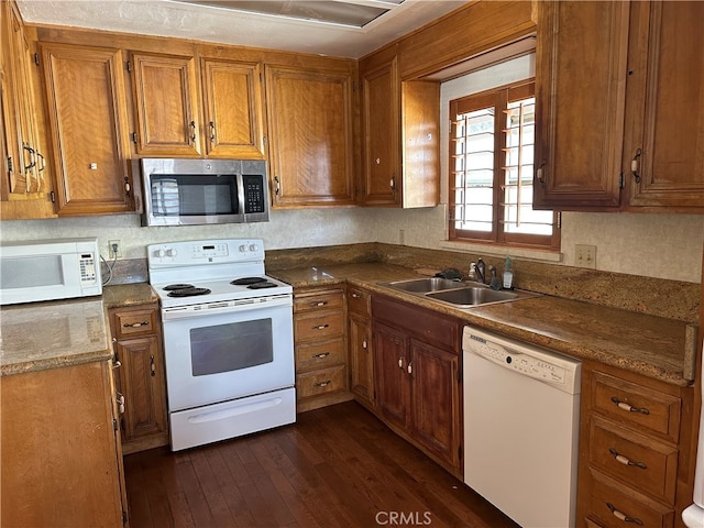 kitchen with sink, dark wood-type flooring, and white appliances