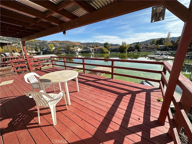 wooden terrace featuring a water and mountain view