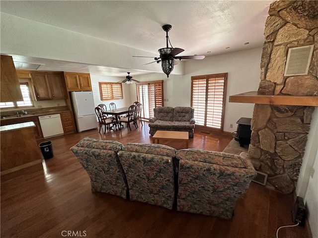 living room with ceiling fan, hardwood / wood-style flooring, plenty of natural light, and a textured ceiling