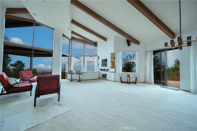 carpeted living room with high vaulted ceiling and beam ceiling