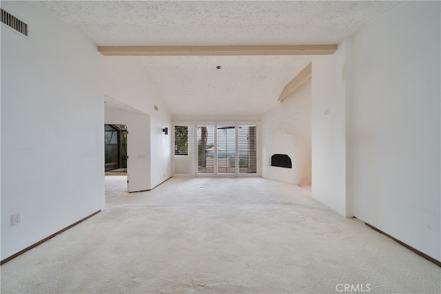 unfurnished living room featuring a textured ceiling, vaulted ceiling with beams, and light colored carpet