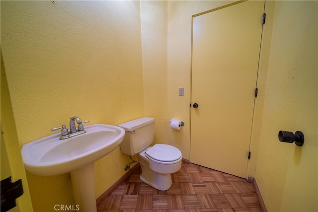 bathroom with parquet floors and toilet