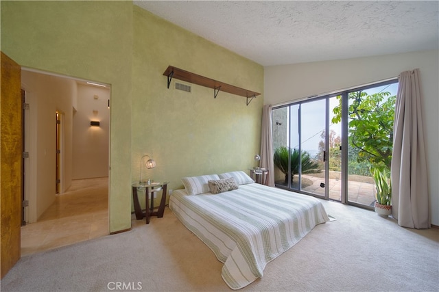 bedroom featuring vaulted ceiling, a textured ceiling, light colored carpet, and access to exterior