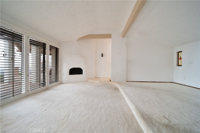 unfurnished living room featuring a textured ceiling, beam ceiling, and a wealth of natural light