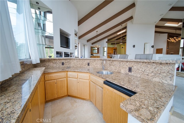 kitchen with vaulted ceiling with beams, sink, a chandelier, dishwasher, and light stone countertops