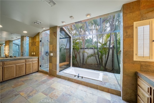 bathroom with shower with separate bathtub, vanity, and tile walls