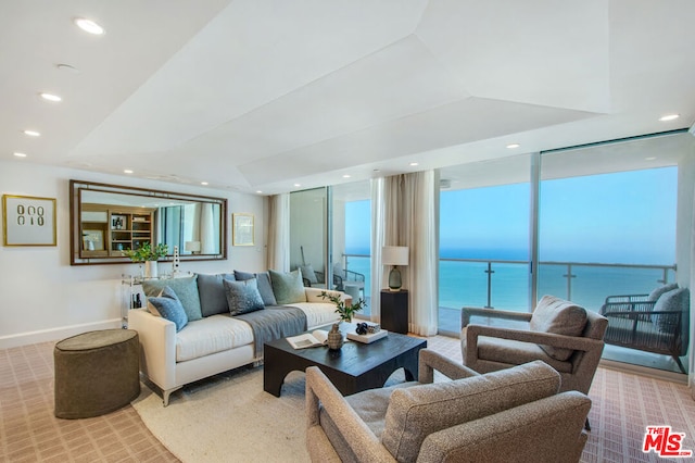 carpeted living room with a water view, radiator heating unit, and plenty of natural light