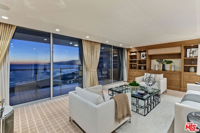 living room with light carpet and a water view