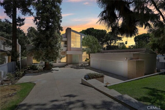 view of front of home with a balcony, a yard, and a garage