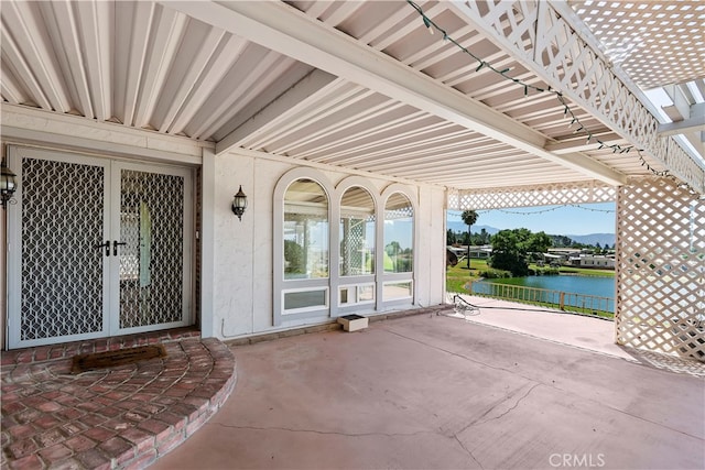 view of patio / terrace featuring french doors and a water view