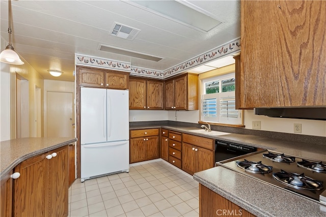 kitchen featuring light tile patterned flooring, white refrigerator, black dishwasher, decorative light fixtures, and sink