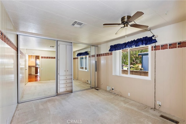 unfurnished bedroom with ceiling fan, light carpet, and a closet