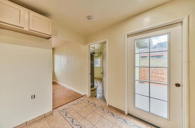 doorway to outside with light tile patterned flooring