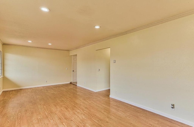 spare room featuring light hardwood / wood-style flooring and crown molding