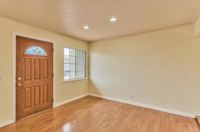 foyer entrance featuring ornamental molding and light hardwood / wood-style flooring