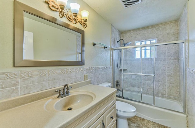 full bathroom with tasteful backsplash, vanity, shower / bath combination with glass door, tile walls, and toilet