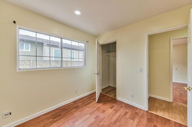 unfurnished bedroom featuring hardwood / wood-style floors and a closet