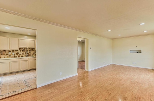 unfurnished living room featuring light hardwood / wood-style flooring and crown molding