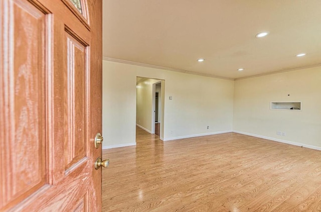 unfurnished room with crown molding and light hardwood / wood-style flooring