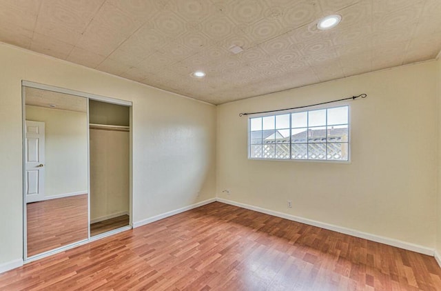 unfurnished bedroom featuring a closet and hardwood / wood-style flooring