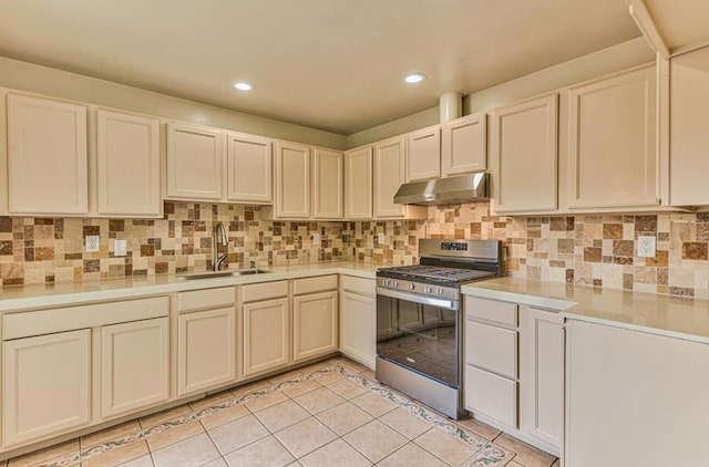 kitchen featuring tasteful backsplash, sink, light tile patterned floors, cream cabinets, and stainless steel gas stove