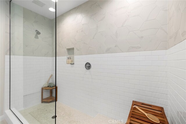 bathroom featuring tile walls and tiled shower