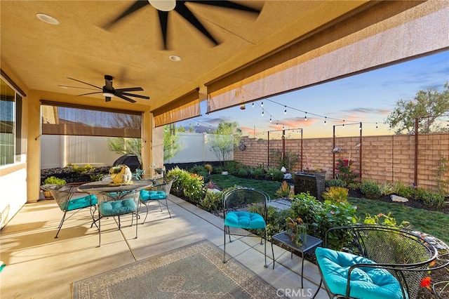 patio terrace at dusk featuring ceiling fan