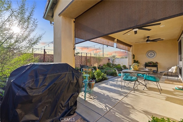 patio terrace at dusk with area for grilling and ceiling fan