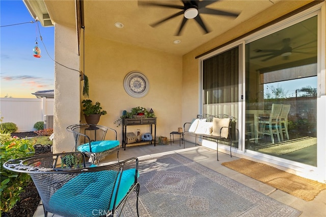 patio terrace at dusk featuring ceiling fan