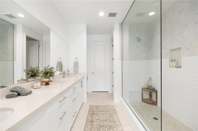 bathroom with double vanity, visible vents, walk in shower, and a sink