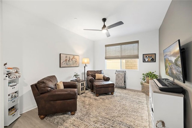 interior space featuring light wood finished floors, baseboards, and a ceiling fan