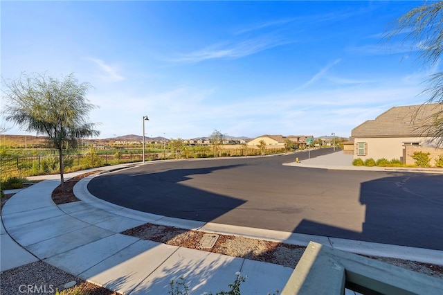 exterior space with street lights, curbs, sidewalks, and a mountain view