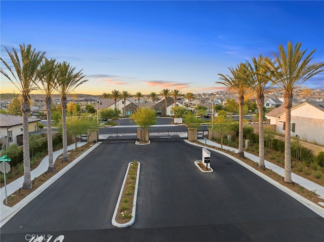 view of road featuring curbs, a gated entry, and a residential view