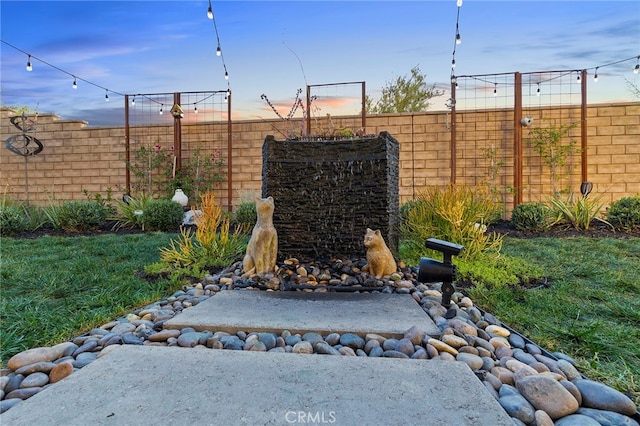 patio terrace at dusk with a fenced backyard