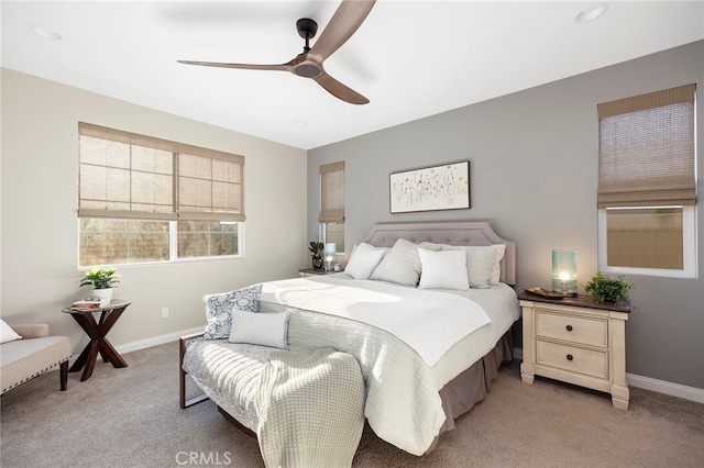 bedroom with light colored carpet, ceiling fan, and baseboards