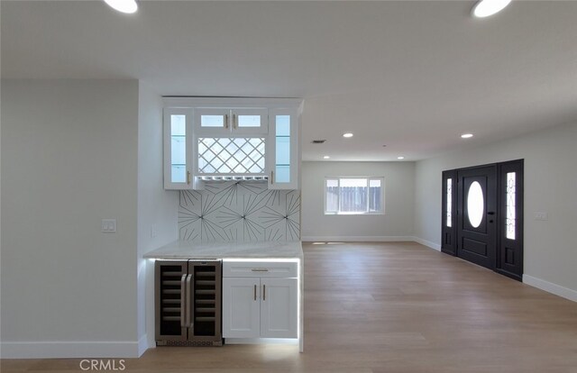 foyer with light hardwood / wood-style floors and beverage cooler