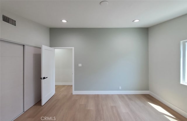 unfurnished bedroom with light hardwood / wood-style floors and a closet