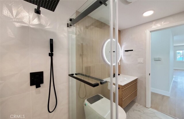 bathroom featuring vanity, toilet, and a shower with door