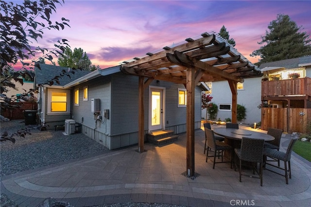 patio terrace at dusk with a pergola and central air condition unit