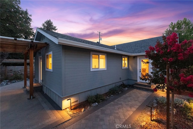 property exterior at dusk with a patio area