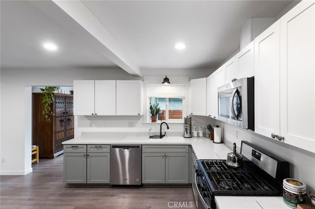 kitchen with gray cabinetry, dark hardwood / wood-style flooring, stainless steel appliances, and white cabinets