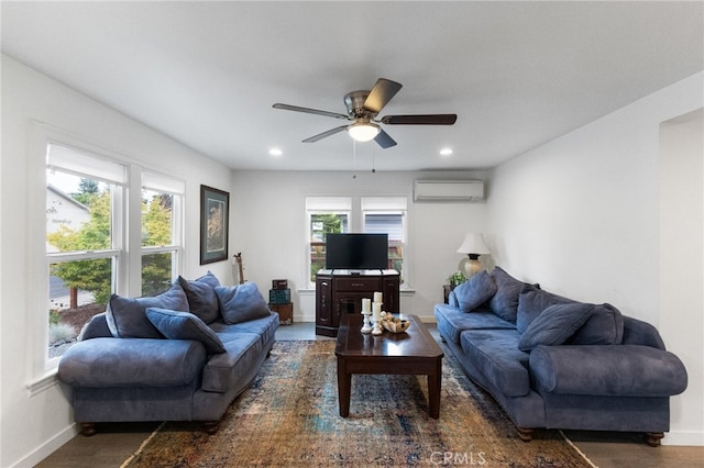 living room with a healthy amount of sunlight, an AC wall unit, and ceiling fan