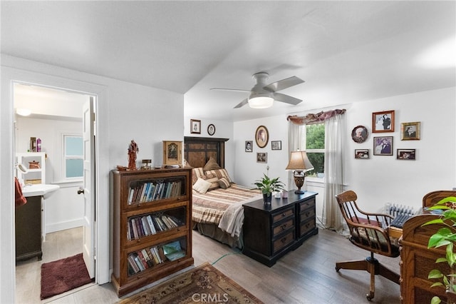 bedroom featuring light hardwood / wood-style floors, ceiling fan, and ensuite bathroom