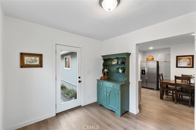 kitchen with stainless steel refrigerator with ice dispenser and light hardwood / wood-style floors