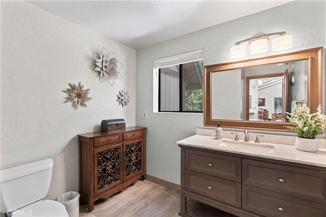 bathroom with vanity, hardwood / wood-style flooring, and toilet